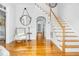 Bright foyer with hardwood floors, staircase, elegant mirror, and an inviting seating area at 3001 Greystone Dr, Rocky Mount, NC 27804