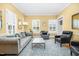 Bright living room with yellow walls featuring stylish seating, layered rug, and large windows for ample natural light at 3001 Greystone Dr, Rocky Mount, NC 27804