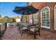 Outdoor patio with brick flooring, table and chairs under an umbrella, and a red brick building in the background at 3001 Greystone Dr, Rocky Mount, NC 27804