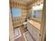 Well-lit bathroom with a patterned accent wall, vanity, and tile flooring at 3098 Creek Point Rd, Graham, NC 27253