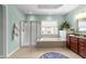 Beautiful primary bath boasts a glass shower, soaking tub, and granite vanity with lovely natural light at 312 Alliance Cir, Cary, NC 27519