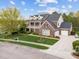 Stately home with a welcoming front porch, lush landscaping, and a three-car garage at 312 Alliance Cir, Cary, NC 27519