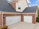 Spacious three-car garage with brick accents and well-maintained driveway at 312 Alliance Cir, Cary, NC 27519