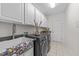 Bright laundry room features white cabinets, utility sink, and new washer/dryer at 312 Alliance Cir, Cary, NC 27519