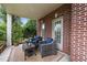 Cozy outdoor patio with comfortable seating, brick columns, and a view of the garden at 312 Alliance Cir, Cary, NC 27519
