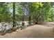 Relaxing back patio with lots of shade provided by mature trees and partial view of the water at 320 Easton Grey Loop, Cary, NC 27519