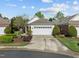 Well-maintained home featuring a pristine two-car garage, complemented by lush landscaping and a manicured lawn at 320 Easton Grey Loop, Cary, NC 27519
