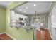 Bright kitchen features white cabinetry, stainless steel appliances, granite countertops, and wood flooring at 320 Easton Grey Loop, Cary, NC 27519