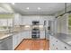 Kitchen featuring stainless steel appliances, white cabinets, and a center island with a stainless countertop at 320 Easton Grey Loop, Cary, NC 27519