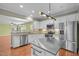 Open-concept kitchen featuring stainless appliances, white cabinets, granite countertops, and a large center island at 320 Easton Grey Loop, Cary, NC 27519