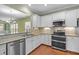 Kitchen featuring stainless appliances, granite countertops, tile backsplash, and white cabinets with under-cabinet lighting at 320 Easton Grey Loop, Cary, NC 27519