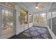 Cozy sunroom with multiple windows, ceiling fan, and a patterned blue rug on dark composite flooring at 320 Easton Grey Loop, Cary, NC 27519