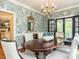 Charming dining room featuring floral wallpaper, a wood table, and French doors to the outside at 3320 Marblehead Ln, Raleigh, NC 27612