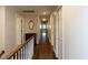 View of hallway with hardwood flooring, neutral paint, closet doors, and decorative mirror at 3320 Marblehead Ln, Raleigh, NC 27612
