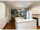 Bright, updated kitchen with white cabinets, stainless appliances, and island with cooktop and eat in dining table at 3320 Marblehead Ln, Raleigh, NC 27612