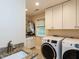 Bright laundry room features granite counters, cabinets, sink, washer and dryer at 3320 Marblehead Ln, Raleigh, NC 27612