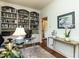 Spacious office with built-in bookshelves, a glass desk, and an adjacent hallway at 3320 Marblehead Ln, Raleigh, NC 27612