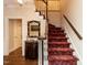 Traditional staircase with red patterned carpet and white wood trim in a light-filled foyer at 3320 Marblehead Ln, Raleigh, NC 27612