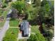 Aerial view of a home with mature trees, colorful landscaping, a brick patio, and a dark roof at 3609 Hawthorne Rd, Rocky Mount, NC 27804
