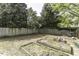 Spacious backyard with wooden garden beds, a wooden fence, and mature shade trees at 3609 Hawthorne Rd, Rocky Mount, NC 27804