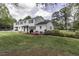Two-story home with a lush green lawn, blooming azaleas, and a patio area with a grill at 3609 Hawthorne Rd, Rocky Mount, NC 27804