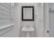 Elegant pedestal sink in bathroom with black framed mirror and white plantation shutters at 39 Drayton St, Clayton, NC 27527