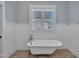 Close up of a clawfoot tub in a charming bathroom with wainscoting and a window at 39 Drayton St, Clayton, NC 27527