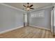 Light-filled bedroom with wood floors, ceiling fan, and large windows with blinds at 39 Drayton St, Clayton, NC 27527