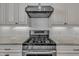 Close-up of stainless steel gas range with granite countertops and white subway tile at 39 Drayton St, Clayton, NC 27527