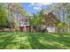 This expansive backyard features mature trees, lush green grass, and a screened in porch at 3928 White Chapel Way, Raleigh, NC 27615