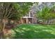 This backyard features mature trees, lush green grass, and a screened in porch off the main house at 3928 White Chapel Way, Raleigh, NC 27615