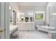 Bathroom featuring marble tile flooring, dual sinks, a soaking tub, and a vanity at 3928 White Chapel Way, Raleigh, NC 27615