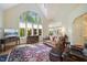 Open-concept living room with hardwood floors and large arched window at 3928 White Chapel Way, Raleigh, NC 27615