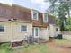 Back exterior of townhouse with double doors that lead to a wood deck and A/C units at 4816 Blue Bird Ct # B, Raleigh, NC 27606