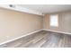 Bright bedroom with neutral paint, hardwood floors, a large window, and updated lighting at 4816 Blue Bird Ct # B, Raleigh, NC 27606