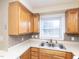 Well-lit kitchen featuring stainless steel sink, tan countertops, and natural wood cabinetry at 4816 Blue Bird Ct # B, Raleigh, NC 27606