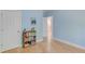 Light-filled bedroom with hardwood floors, blue walls, and a view to an adjoining bath at 490 Shawnee Dr, Louisburg, NC 27549