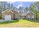 Beautiful stone home featuring a manicured lawn, attached garage, and inviting front porch at 490 Shawnee Dr, Louisburg, NC 27549