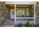 Inviting front porch with stone accents, seating, and a well-maintained entrance at 490 Shawnee Dr, Louisburg, NC 27549