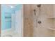 Elegant bathroom shower featuring travertine tile, a hand shower, and a convenient corner shelf at 490 Shawnee Dr, Louisburg, NC 27549