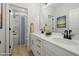Bright, modern bathroom with double sinks, white cabinetry, and a view into the adjacent shower area at 50 Gadwall Ct, Zebulon, NC 27597