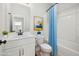 Clean bathroom with a vanity, toilet, and bathtub with a blue shower curtain, offering a functional space at 50 Gadwall Ct, Zebulon, NC 27597