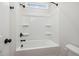 Bathroom featuring white shower-tub combo with built-in shelving and black hardware at 50 Gadwall Ct, Zebulon, NC 27597