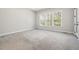 Bright bedroom with plush carpet, base molding, three windows with natural light, and white walls at 50 Gadwall Ct, Zebulon, NC 27597