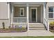 Inviting front porch with white columns, gray siding, and a well-manicured landscape at 50 Gadwall Ct, Zebulon, NC 27597