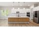 Eat-in kitchen with stainless appliances, quartz countertops, wood island and modern lighting fixtures at 50 Gadwall Ct, Zebulon, NC 27597