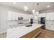 Stylish kitchen features white cabinets, stainless appliances, quartz countertops, and an island with sink at 50 Gadwall Ct, Zebulon, NC 27597