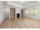 Living room with wood floors, built-in bookshelves, fireplace, recessed lights, and many windows at 50 Gadwall Ct, Zebulon, NC 27597