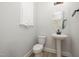 Tastefully designed powder room featuring pedestal sink and round mirror with a decorative light fixture at 50 Gadwall Ct, Zebulon, NC 27597
