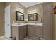 Bathroom with double sinks, cabinets, modern lighting, and decorative mirrors at 503 Fish Pond Ct, Rolesville, NC 27571